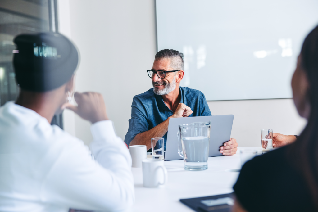 A man discussing with colleagues during a meeting.