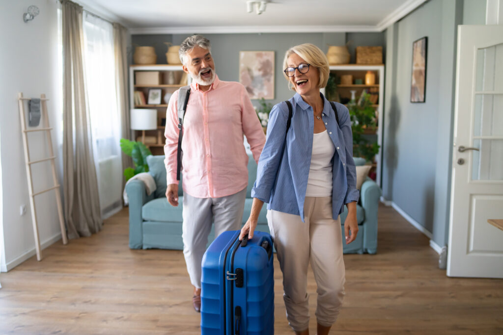 Senior Couple Standing With Suitcase About To Leave For Vacation