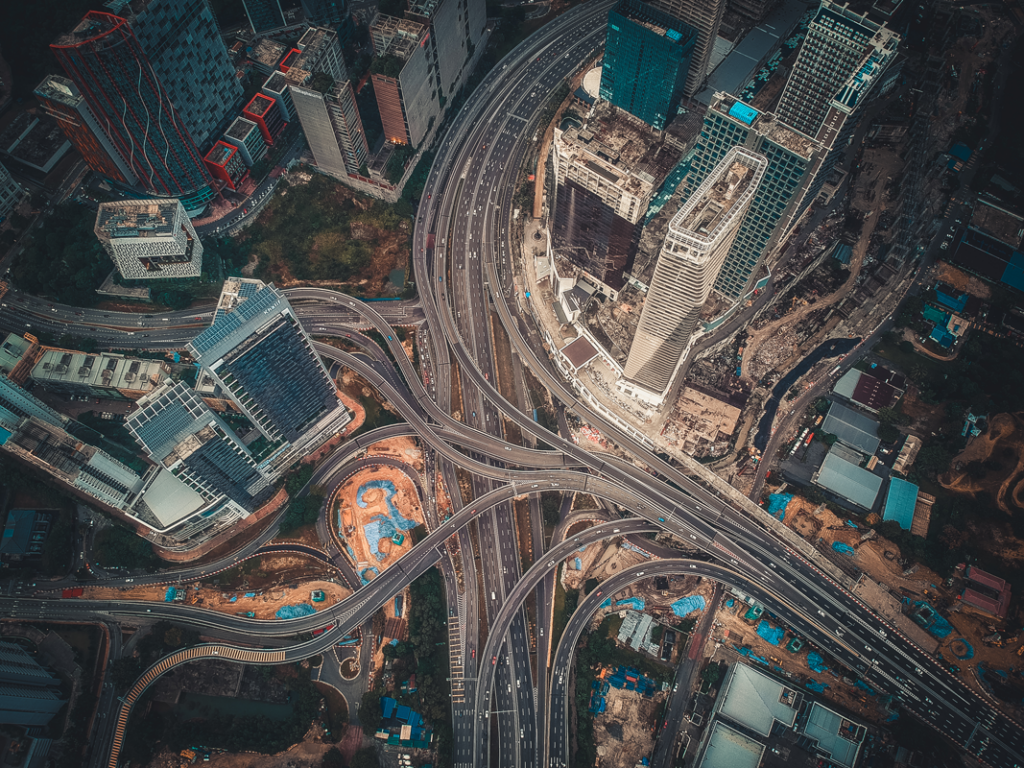 Aerial view of busy city streets and road juntions including high rise buildings and overpasses