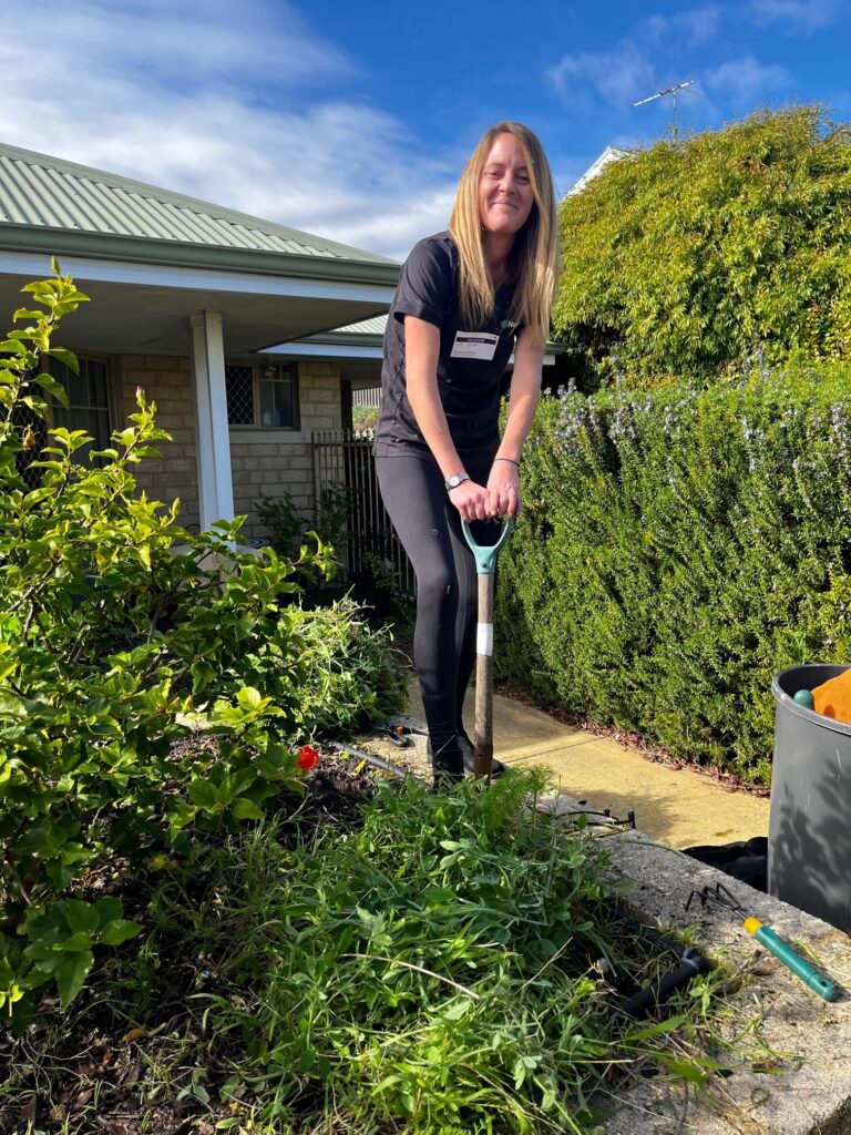 Employee of Nexia Perth gardening at aged care facility during Nexia Week